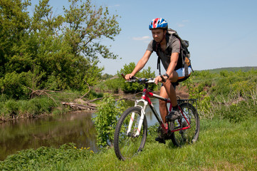 Obraz premium Mountain biker beside a beautiful river