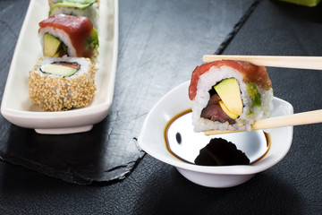 eating sushi rolls / close up of chopsticks taking sushi roll