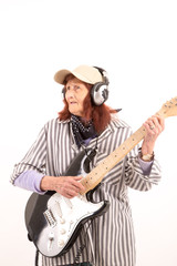 Funny elderly lady playing electric guitar.