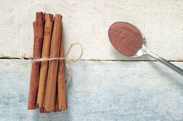 Cinnamon sticks tied next, a spoon with some powdered cinnamon.