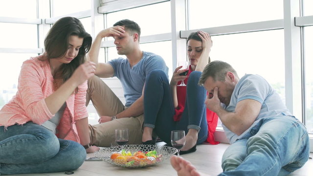 Worried friends sitting on the friends and drinking wine
