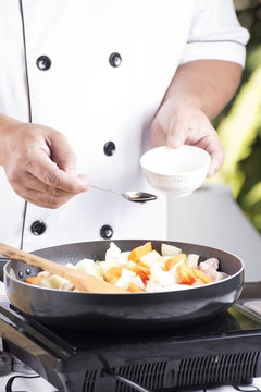 Chef putting seasoning sauce to the pan for cooking Japanese por