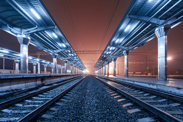 Treinstation bij nacht. Treinplatform in mist. Spoorweg