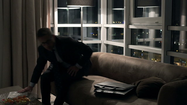 Tired businessman coming to apartment after work 
