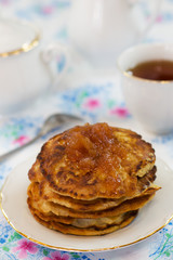 pear pancakes with jam and tea on a white plate and blue tablecloths