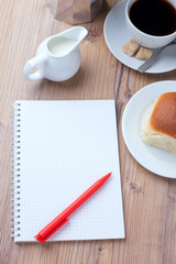 bun with coffee and notepad