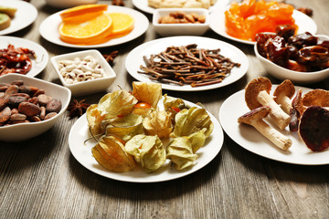 Different products on saucers on wooden table, closeup