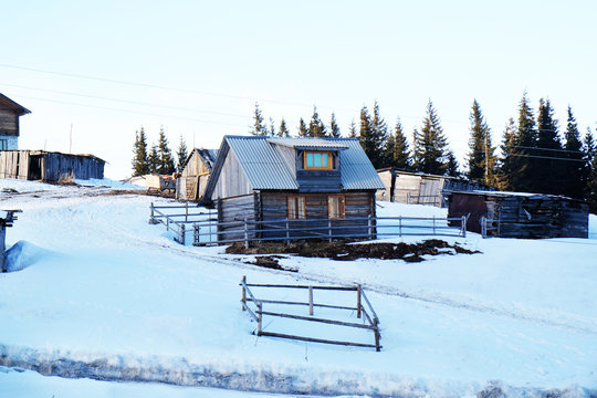 Wooden buildings over snow and sky in wintertime