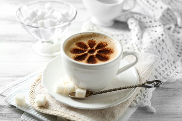 Cup of latte coffee art on wooden table, on light background