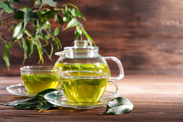 Cups of green tea on table on wooden background