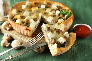 Cheese pie with mushrooms, herbs and sour creme, on color wooden table background