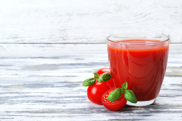Glass of tomato juice with vegetables on wooden background