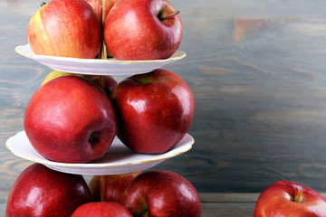 Tasty ripe apples on serving tray on wooden background