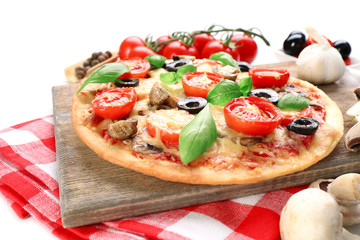 Tasty pizza with vegetables and basil close up