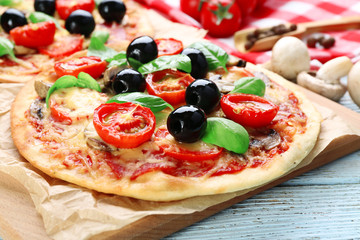 Tasty pizza with vegetables and basil on table close up