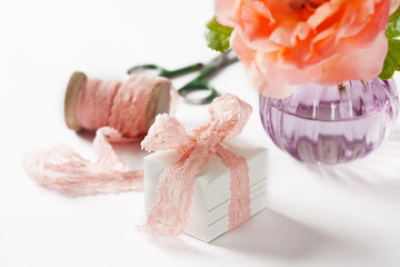 Decorated gift box and rose in vase on white