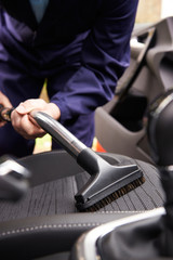 Man Hoovering Seat Of Car During Car Cleaning