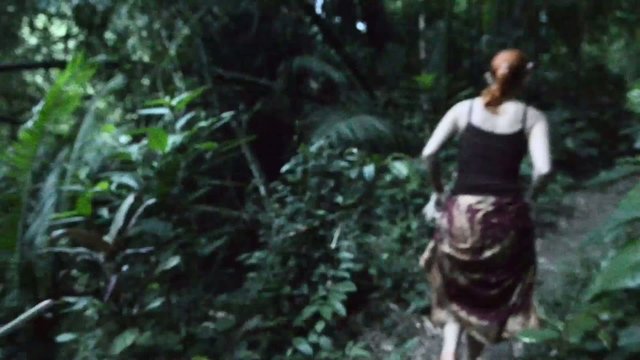 Young woman running thorough jungle