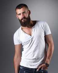 Fototapeta premium Portrait of handsome bearded man standing, isolated on grey