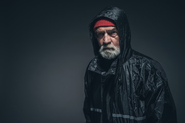 Bearded Adult Guy in Rain Jacket Against Black
