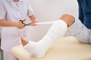 Female Doctor Bandaging Patient's Leg