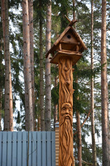 Funny Wooden mask on the fir tree trunk