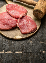 Veal schnitzel preparation on rustic wooden background