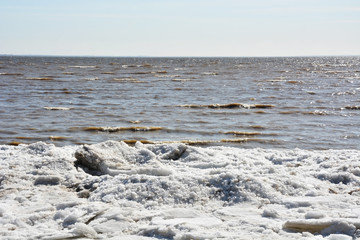 Coastal line with ice and sea. Spring season