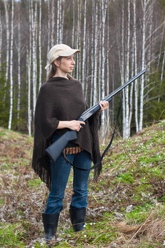 female hunter with gun in the forest