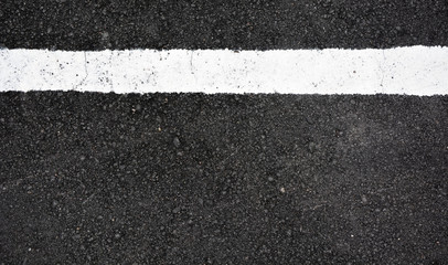 Strip of white paint on the asphalt road