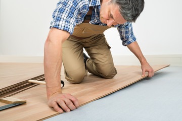 Man Installing New Laminated Wooden Floor