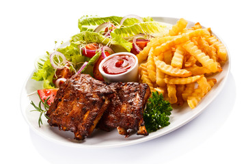 Grilled ribs, French fries and vegetables on white background 