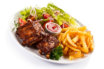 Grilled ribs, French fries and vegetables on white background 