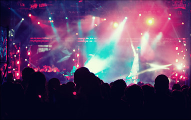 Fototapeta na wymiar Cheering crowd in front of stage lights - retro photo