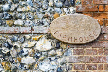 Sign for Farmhouse on medieval stone wall pattern as a backgroun