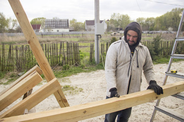 a man with a beard, a builder, working with wood, wood grinder g