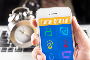 Hand holding smart phone with home control application with cloc