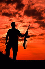 Fototapeta na wymiar silhouette of a soldier with a gun 