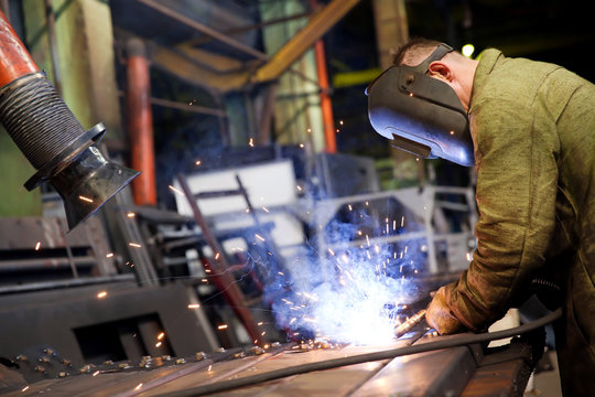 Factory welder worker during gas metal arc welding works