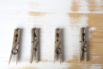 four clothespins on white wooden background