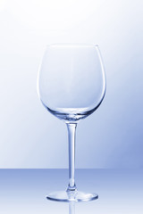 An empty red wine glass in slightly blue light