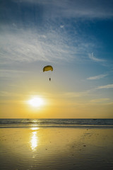 paragliding over the sea in the sunset time