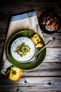 Cream soup with bread and meat on wooden background
