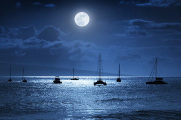 Moonlit nighttime sky over a calm ocean scene in Maui Hawaii - 83823722