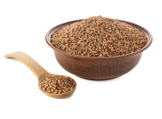 Buckwheat in bowl with wooden spoon on white.