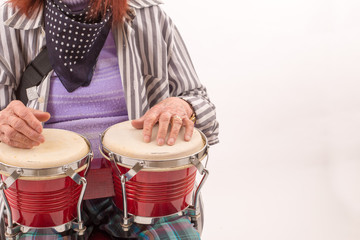 Funny elderly lady playing bongo.