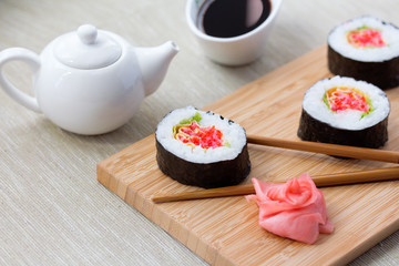 Sushi rolls with ginger, soy sauce and chopsticks