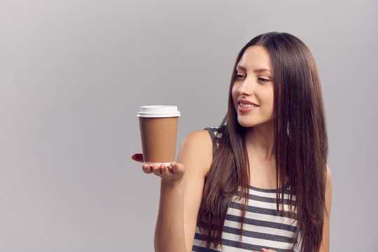 Woman drinking hot drink from disposable paper cup