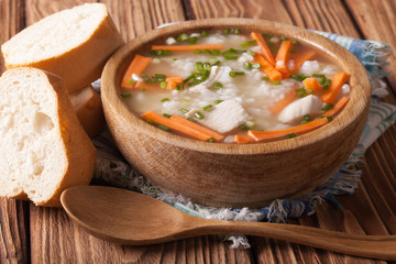 Homemade Food: Chicken rice soup in a wooden bowl. Horizontal
