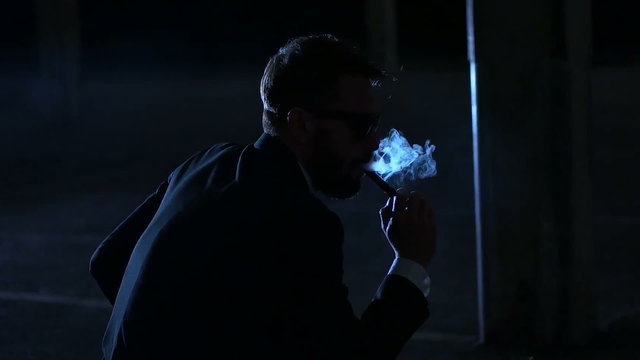 man smoking e-cigarette wearing suit